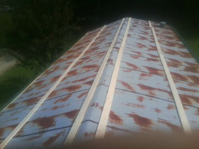 Rusted metal roof panels with new wood purlins before replacement — Storm Damage Roof Repair in Connell by Roofing Brothers