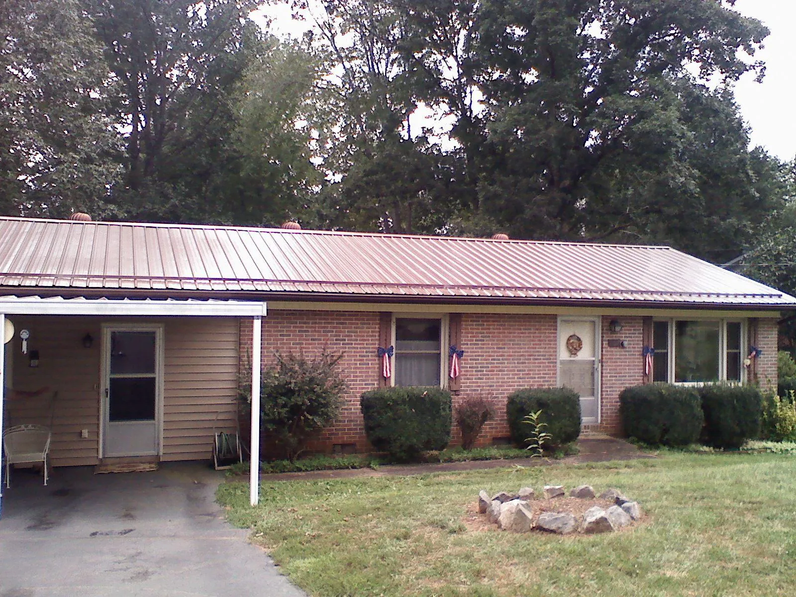 Bronze metal roof and carport on a brick ranch home — Roof Repair work by our crew in Connell
